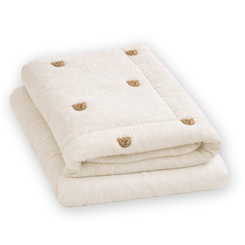 Cream-colored baby blanket neatly folded with small brown bear face embroidery pattern.