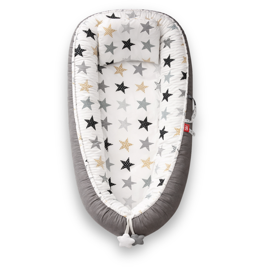 Grey baby lounger with white interior and multicolored star pattern, viewed from above.