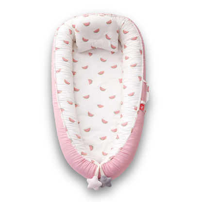 Pink baby lounger with white interior and small watermelon print, viewed from above.