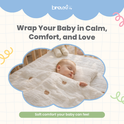 Baby sleeping peacefully covered with a cream-colored blanket featuring brown bear face embroidery.