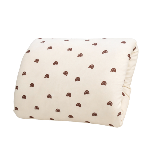 Cream-colored nursing pillow with small brown rainbow pattern, shown from a front angled view.